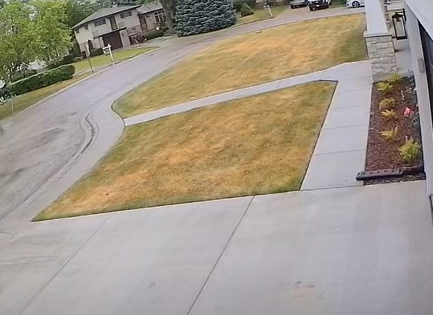 barber using styling spray on young man with black hair, short on sides and long in a quiff on top